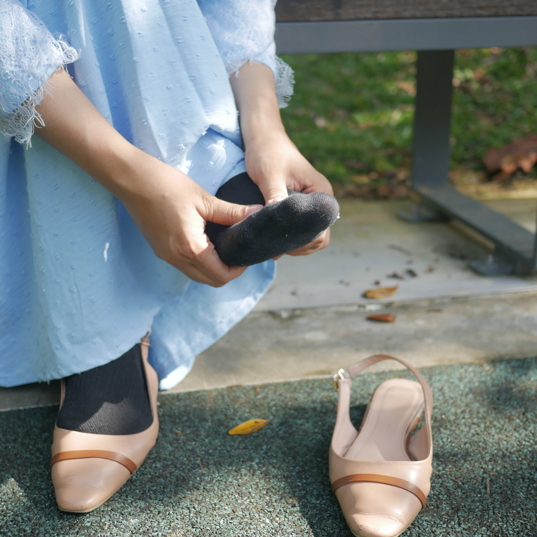 Talpi bönye gyulladassal szenvedo holgy ul a padon es probalja enyhiteni a fajdalmat masszirozassal